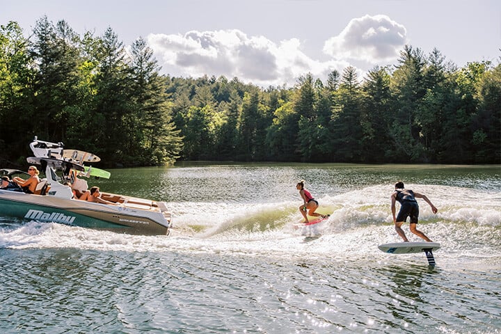 One person wakesurfing and one person wakefoiling behind the All-New 2025 Malibu Wakesetter 25 LSV