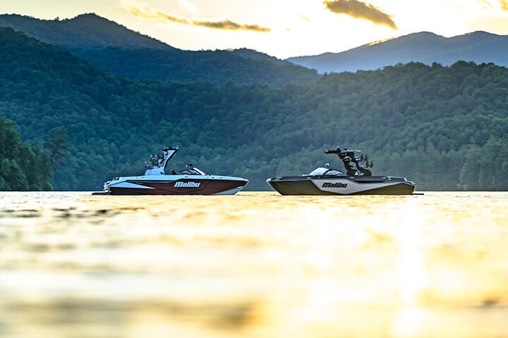 Malibu M230 and M242 sitting bow to bow in front of mountains